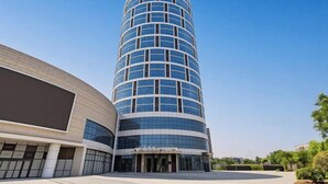 A modern hotel with a curved facade, large glass windows, and a spacious entrance area.