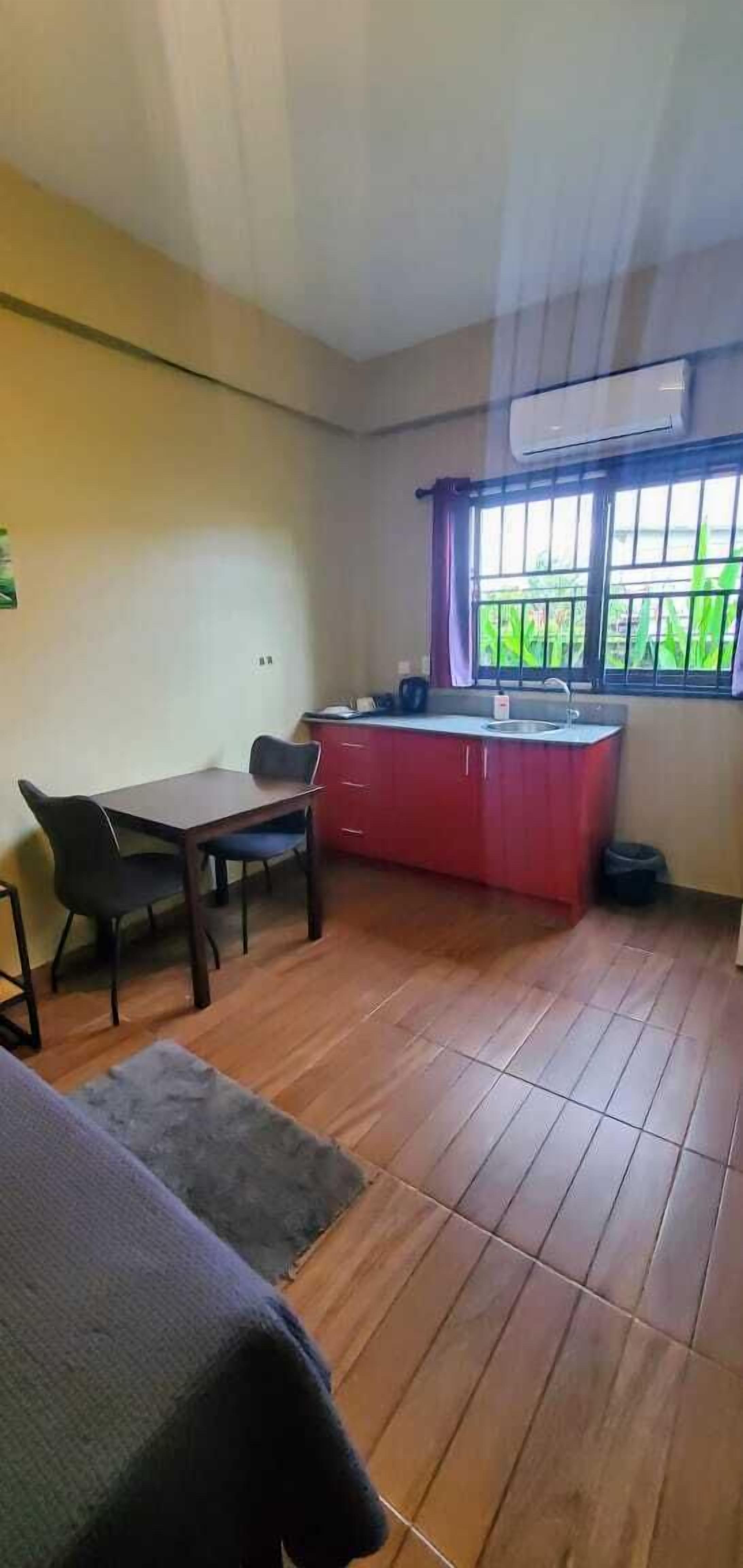 A small, compact room with a kitchenette, a dining table, and a single chair.