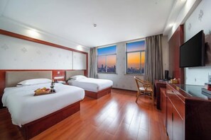 A hotel room with two beds, a desk, a TV, and a cityscape view. - NOMC Hotel (Xianju)