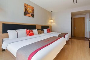 A hotel room with two beds, a headboard, a painting on the wall, and a door. - Shankee Hotel (Nanjing South Railway Station Shuanglong Avenue Subway Station) (Nanjing)