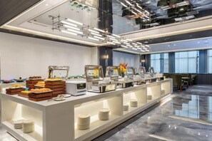 A modern breakfast buffet with various food items and self-service stations. - Junrui Huasheng International Hotel (Zhuzhou)