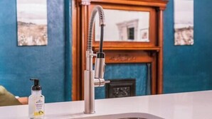 Une salle de bain moderne avec un lavabo blanc, un meuble-lavabo en bois et un mur bleu.