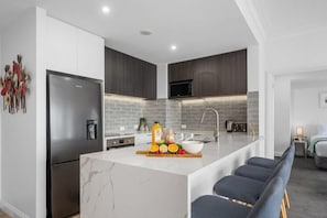 Enjoy cooking in this well-equipped kitchen with a sink and refrigerator.