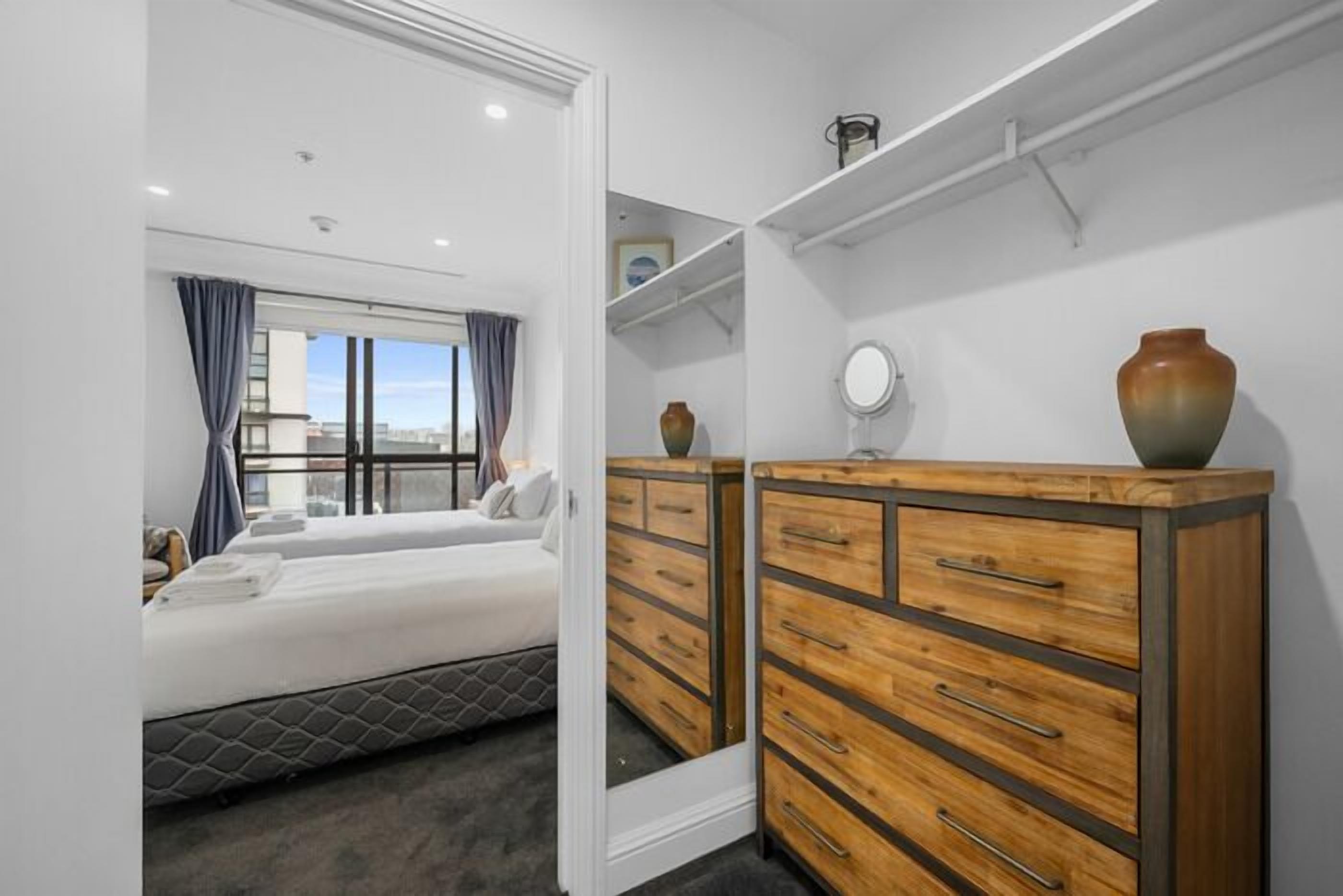 Una camera da letto moderna con un letto, una cassettiera e una finestra con tende.