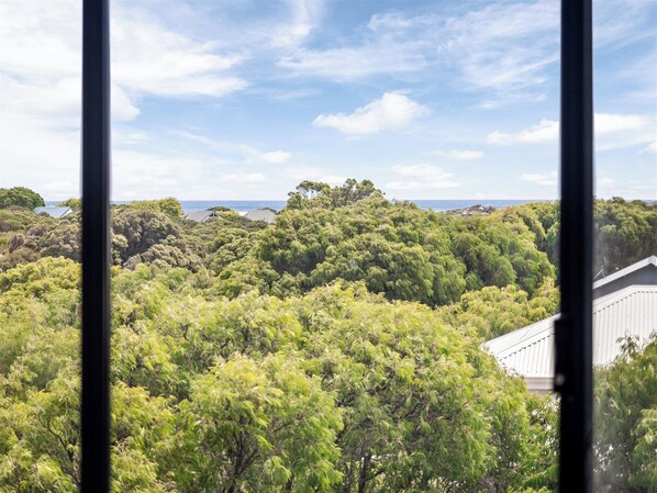 A view of a lush, green landscape with dense foliage and a distant body of water. - The Office Escape - NEW (Gnarabup)