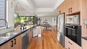Une cuisine moderne avec des meubles en bois, des appareils en acier inoxydable et un grand îlot central.
