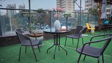 An outdoor seating area with a round table, chairs, and a potted plant.