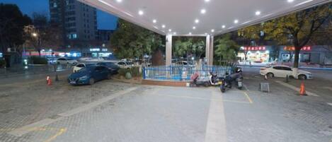 A gas station with multiple fuel pumps, a paved parking area, and a fence.