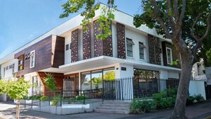 A modern two-story house with a flat roof, large windows, and a balcony. - Hotel Madero Talca (Talca)