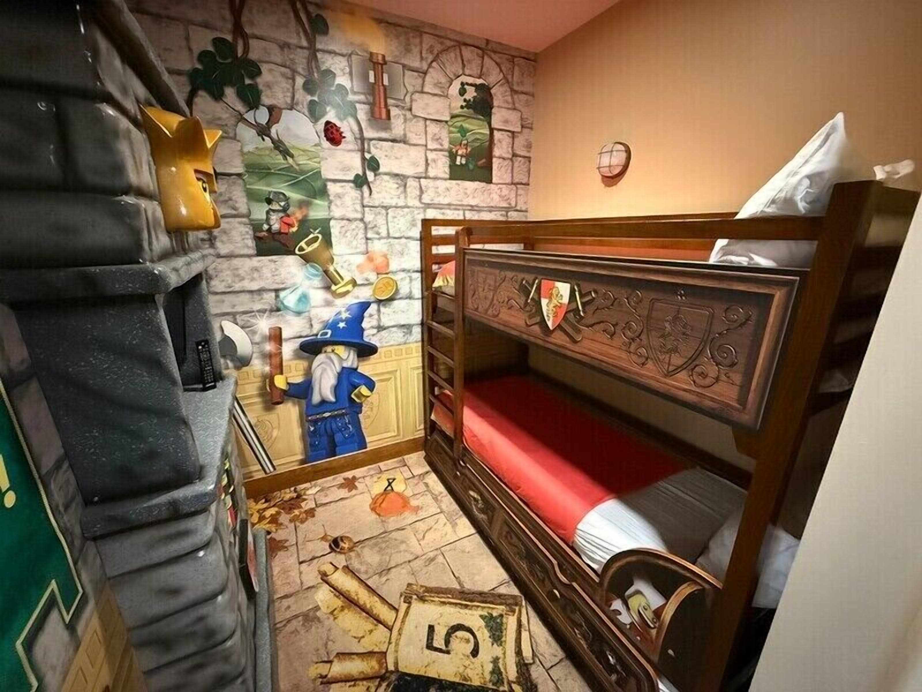 Een kinderkamer met een stapelbed, een tovenaarfiguur en een schatkist.