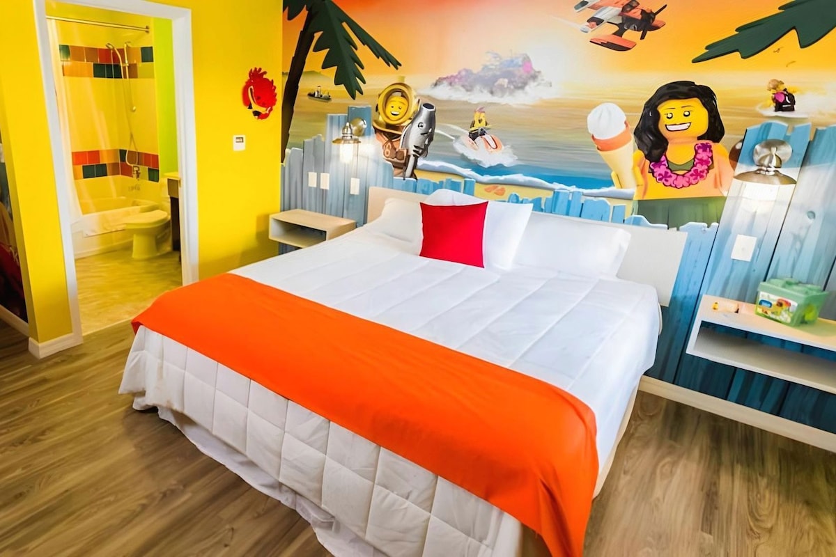 Une chambre d’hôtel avec un lit, une douche et une fresque murale.