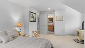 Un dormitorio con cama, lámpara de noche y cómoda.