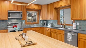Una cocina moderna con armarios de madera, electrodomésticos de acero inoxidable y una isla grande.