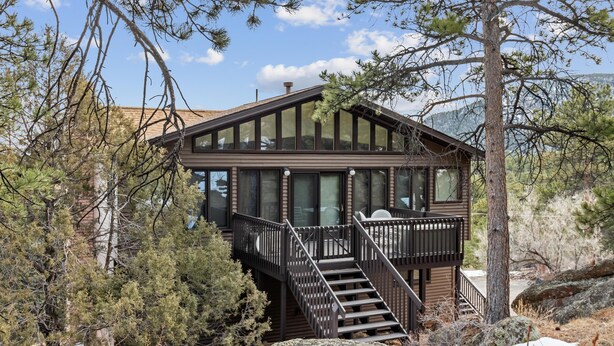 A cabin with a wooden exterior, a balcony, and a staircase leading to the upper level. - Elkhorn West -Amazing views! Close to town! (Estes Park)