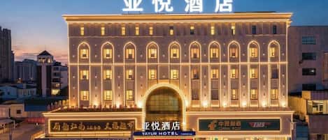 Un hotel con una amplia entrada en arco, múltiples ventanales y señalización que indica que es el Yayur Hotel.