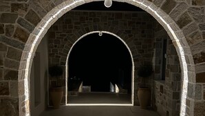Una entrada de piedra en arco con una lámpara colgante.