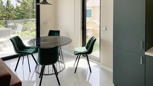 A modern dining area with a round table, four chairs, and a cabinet.