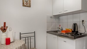 Pieni ja käytännöllinen keittiö, jossa on kaasuliesi, vedenkeitin ja pesuallas. Keittiössä on pieni pöytä, jonka päällä on kukkakuviollinen pöytäliina, sekä yksi tuoli. Seinällä pöydän yläpuolella on kehystetty taulu.
