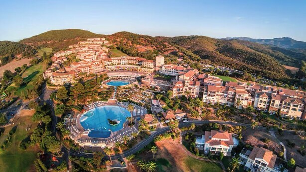 A resort with multiple buildings, a large central pool, and surrounding greenery. - Stone and vacation apartment with covered parking space and pool access. (Saint-Raphaël)