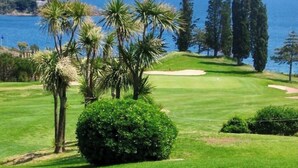 A golf course with a clear view of the ocean and a lighthouse in the distance. - Stone and vacation apartment with covered parking space and pool access. (Saint-Raphaël)
