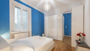 A bedroom with a bed, a dresser, a mirror, and a window. - GIACOSA, 71 – Spacious apartment for 6 (Milano)