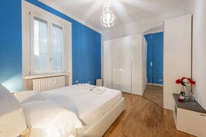 A bedroom with a bed, a dresser, a mirror, and a window. - GIACOSA, 71 – Spacious apartment for 6 (Milano)
