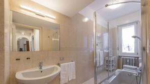 A modern bathroom with a sink, mirror, and shower. - Otto Novembre, 3 – Spacious and Elegant with a View (Milano)