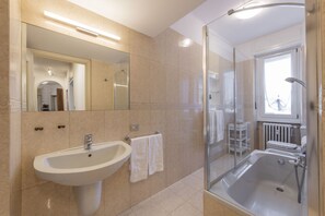 A modern bathroom with a sink, mirror, and shower. - Otto Novembre, 3 – Spacious and Elegant with a View (Milano)