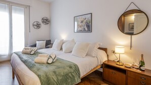A bedroom with a bed, a bedside table with a lamp, a mirror, and artwork on the wall. - Otto Novembre, 3 – Spacious and Elegant with a View (Milano)