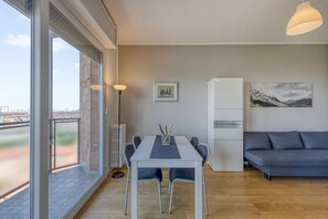 Een moderne woonkamer met een eettafel, bank en kunstwerken aan de wanden.