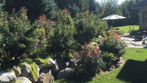 Un jardin bien entretenu, agrémenté de diverses plantes et bordé d’un mur en pierre.