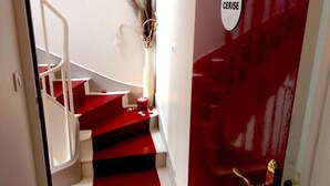 Una scala con gradini rossi che porta a una porta con la scritta 'CERISE'.