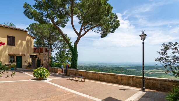 Une cour avec un banc, un lampadaire et une vue sur la campagne.