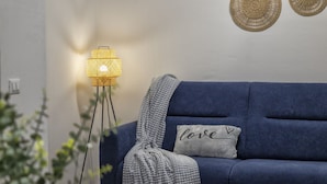 A blue sofa with a gray throw blanket and a pillow with "love" and a heart symbol.