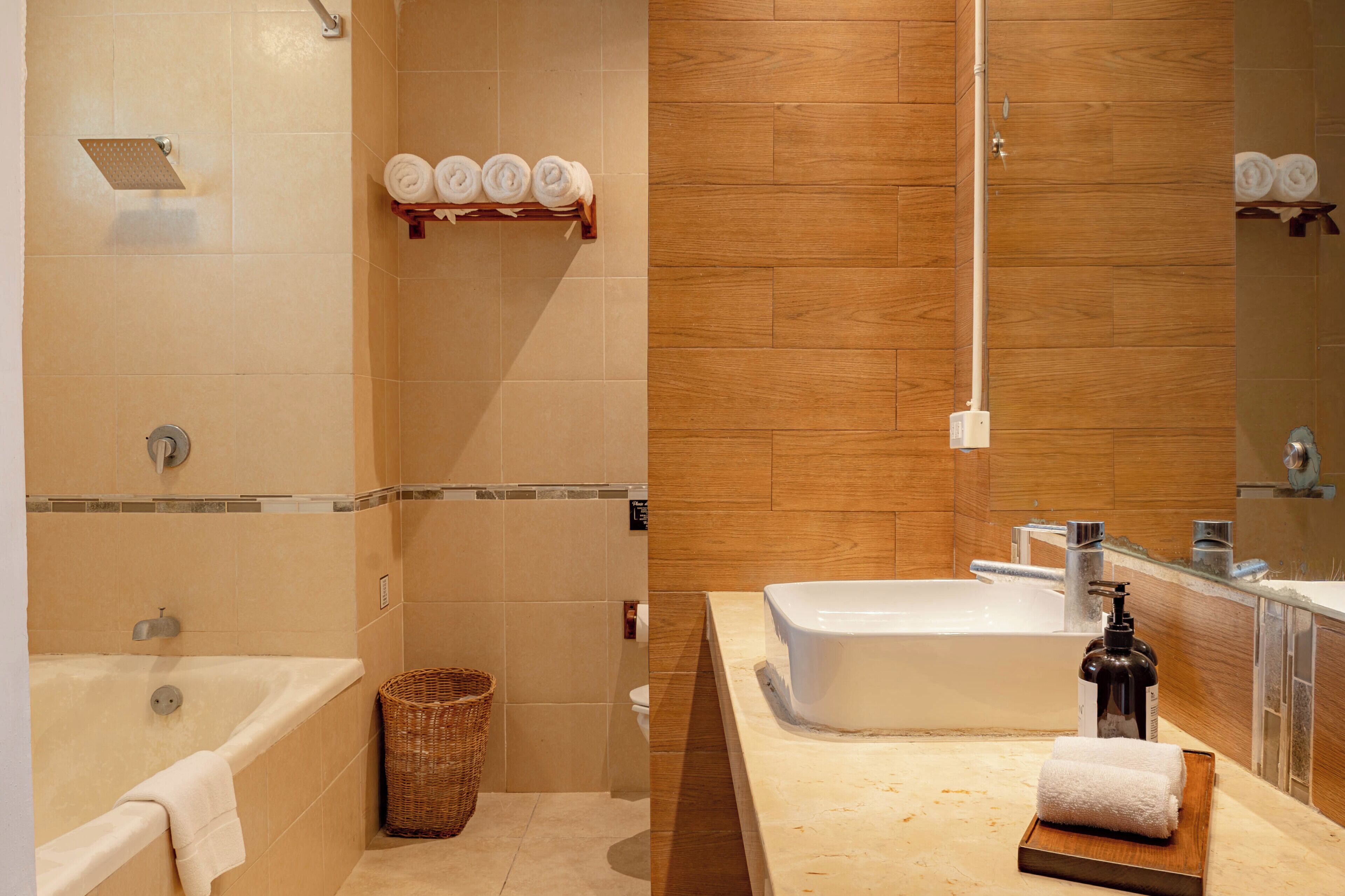 Une salle de bain équipée d’une baignoire, d’une douche, de toilettes, d’un lavabo et d’un miroir.