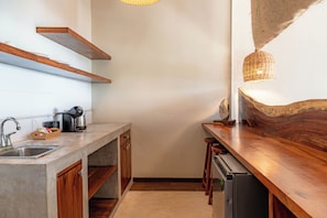 Una cucina con piano di lavoro in legno, lavastoviglie integrata e lampada a sospensione.