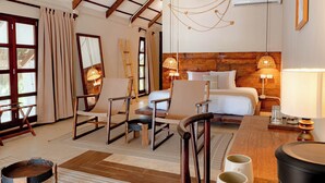 A hotel room with a bed, two chairs, a table, a lamp, and a large window with curtains. - Mia Tulum Beachfront Resort - Ocean View Suites and Beach Club (Tulum)