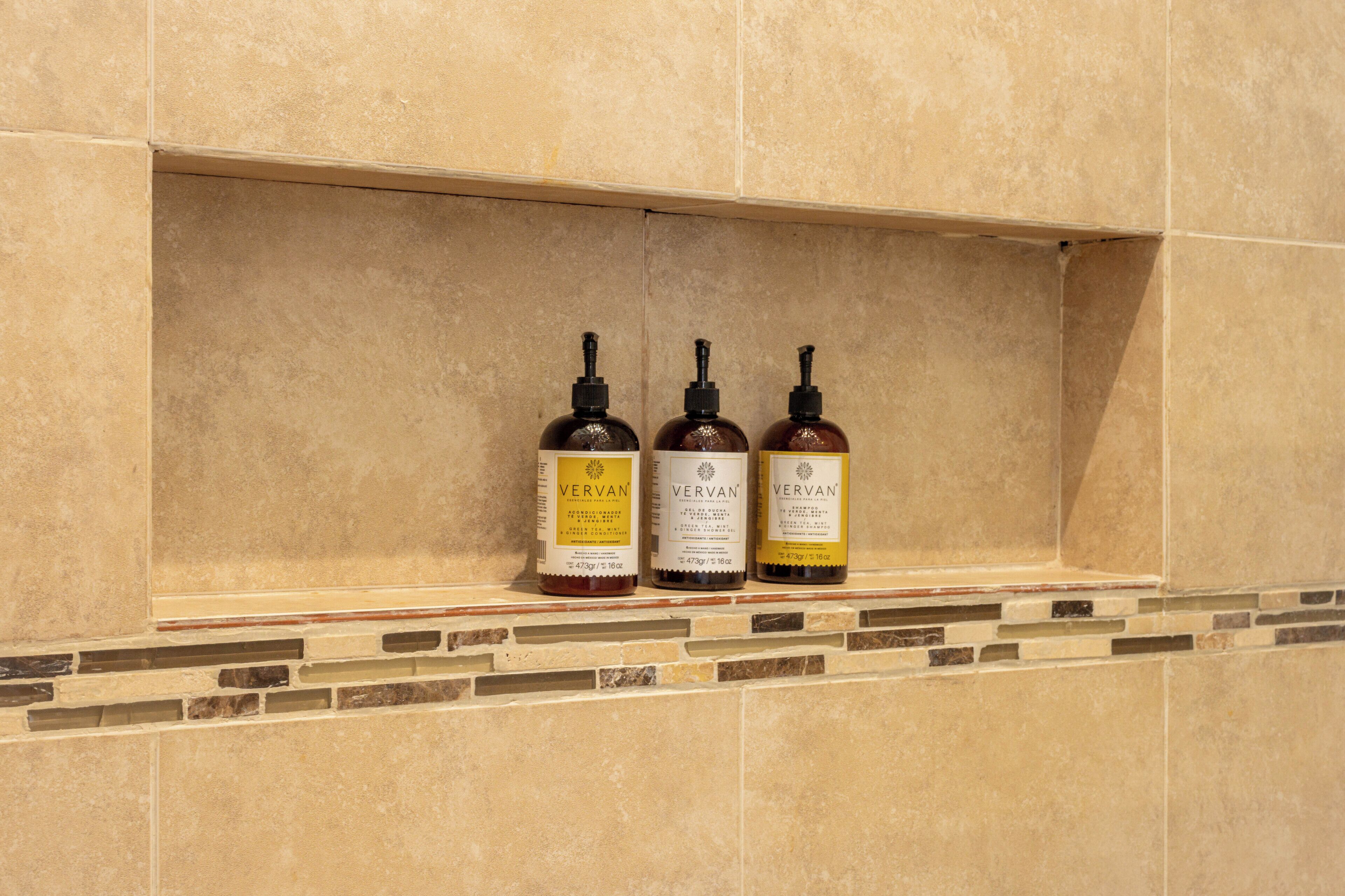 Tres botellas de Vervan sobre un estante de azulejos.