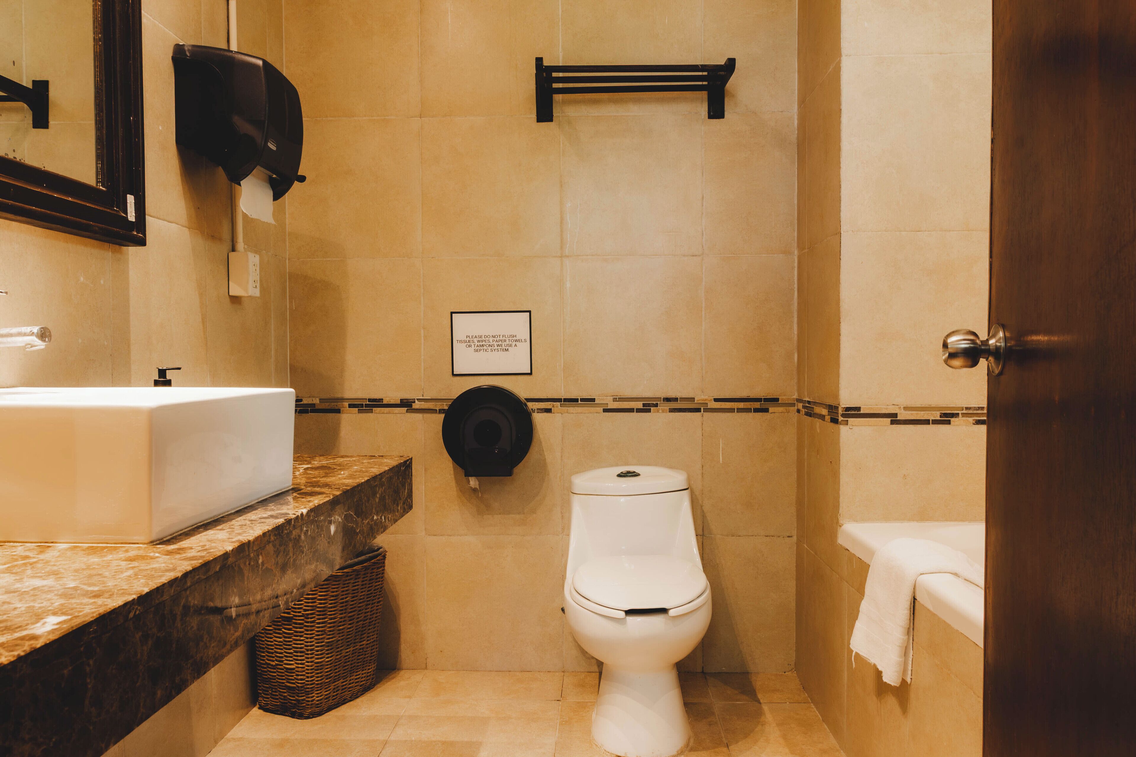Een badkamer met een wastafel, toilet en handdoekrek.