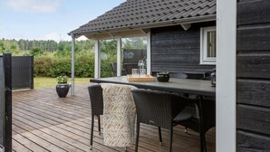 A wooden deck with outdoor furniture, a pergola, and a view of the surrounding greenery. - Gorgeous home in Ebeltoft with sauna (Ebeltoft)