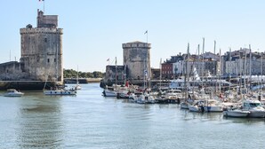 Un puerto con torres históricas y una marina llena de barcos.