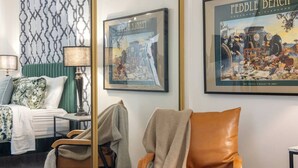 A hotel room with a bed, a chair, a lamp, and two framed pictures on the wall. - Jacuzzi Delight - Luxe 2BD/2BA near UC Davis Med (Sacramento)