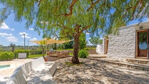 A patio area with outdoor furniture, a tree, and a stone wall. - 3 bedroom cozy home in Ostuni (Ostuni)