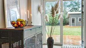 A modern kitchen with a fruit bowl, candles, and pampas grass in a vase. - 4 bedroom stunning home in Væggerløse (Væggerløse)