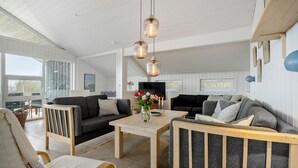 Una sala de estar acogedora con chimenea, dos sofás, una mesa de centro y un televisor.