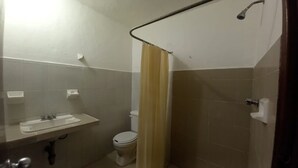 Une petite salle de bain avec un lavabo, des toilettes et une douche.