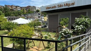 A view of Mercado São Miguel with a playground in the foreground and residential buildings in the background.