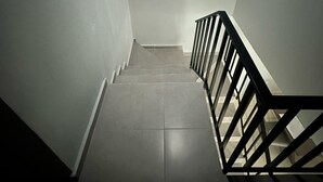 Eine Treppe mit Handlauf und Wandleuchte.