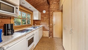 A modern kitchen with wooden walls, a microwave, a coffee maker, and a sink. - Pet friendly home in Haren with WiFi (Haren)