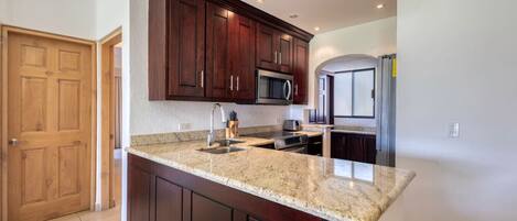 Køleskab, kaffe-/temaskine, køkkentøj/tallerkener/redskaber, spisebord